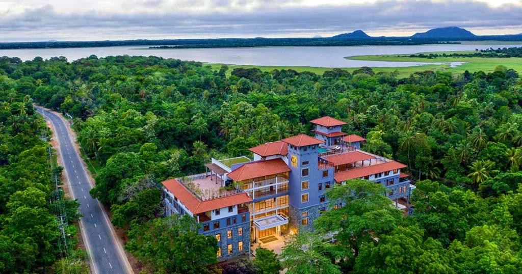 Aerial view of Adhitya Ayurveda surrounded by trees with water in the distance