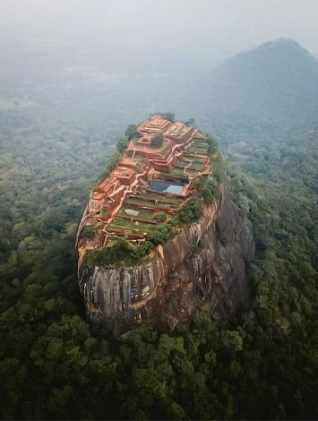 Aerial view of Sigiriya rock fortress surrounded by forest, featured by Adithya Lanka Holidays