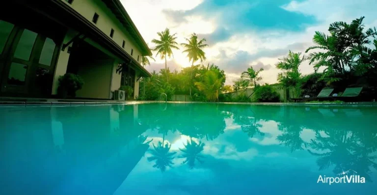 Swimming pool beside Airport Villa with palm trees and tropical greenery
