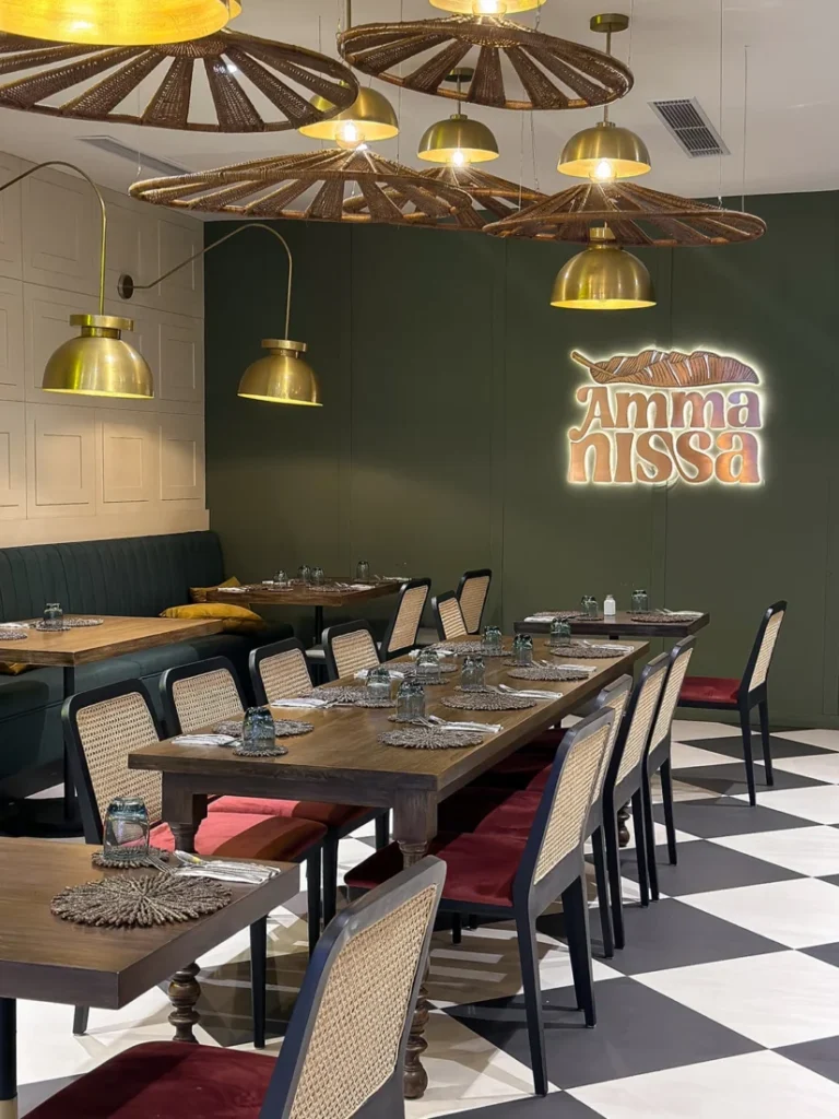 Dining tables, woven lighting and the Amma Nissa sign at its One Galle Face restaurant in Colombo.