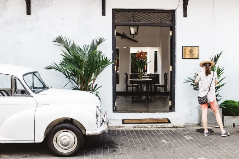 Vintage white car parked beside a building entrance in Galle