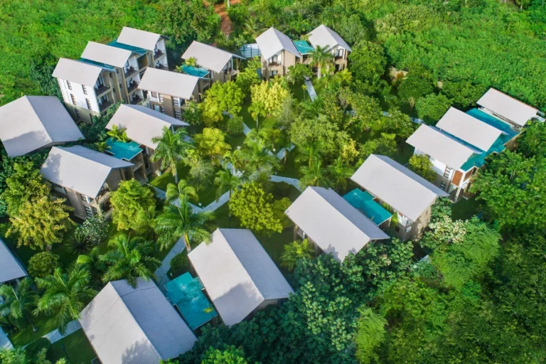 Resort buildings set among dense green trees at Chaarya Resorts and Spa