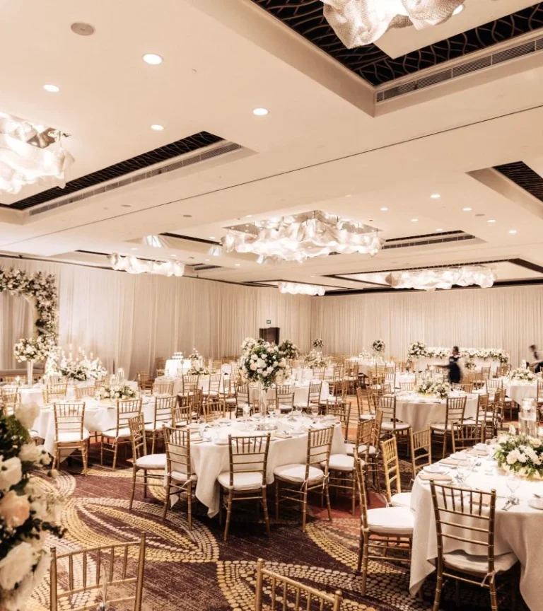 Round banquet tables with white linens and floral centrepieces in Cinnamon Grand Colombo’s Oak Room