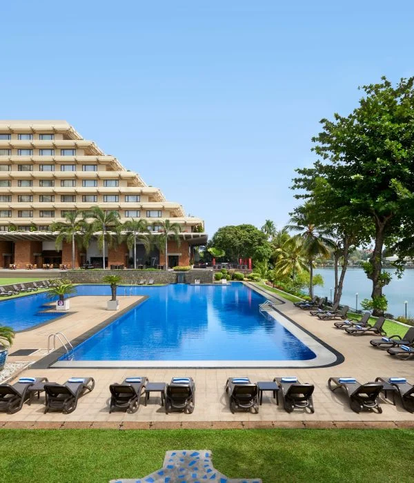 Swimming pool and sun loungers beside the hotel and lake at Cinnamon Lakeside Colombo
