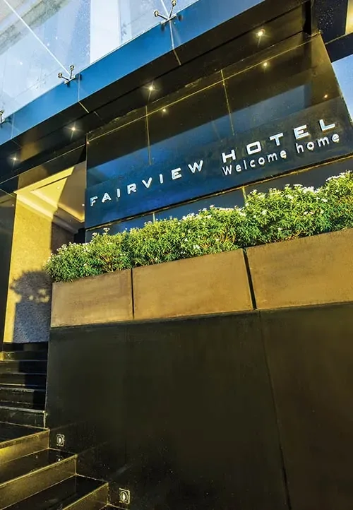 Fairview Hotel entrance with its sign above a planted facade