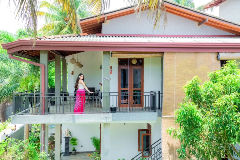 Falkennest Villa exterior with a balcony, red roof and tropical greenery