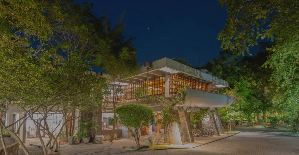 Illuminated resort building surrounded by trees at night