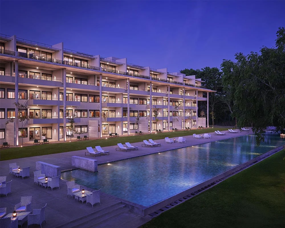 Jetwing Lake hotel building and illuminated swimming pool at dusk