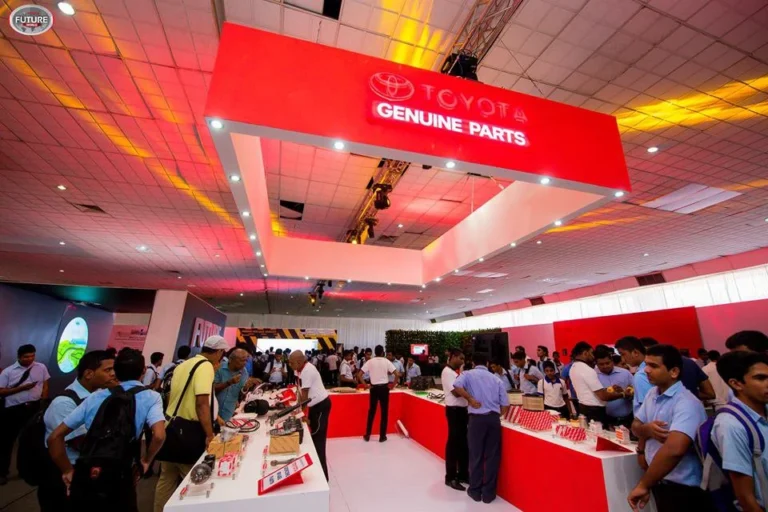 Indoor exhibition with visitors and red overhead event signage