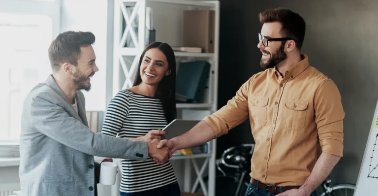 Two people shaking hands during an office meeting